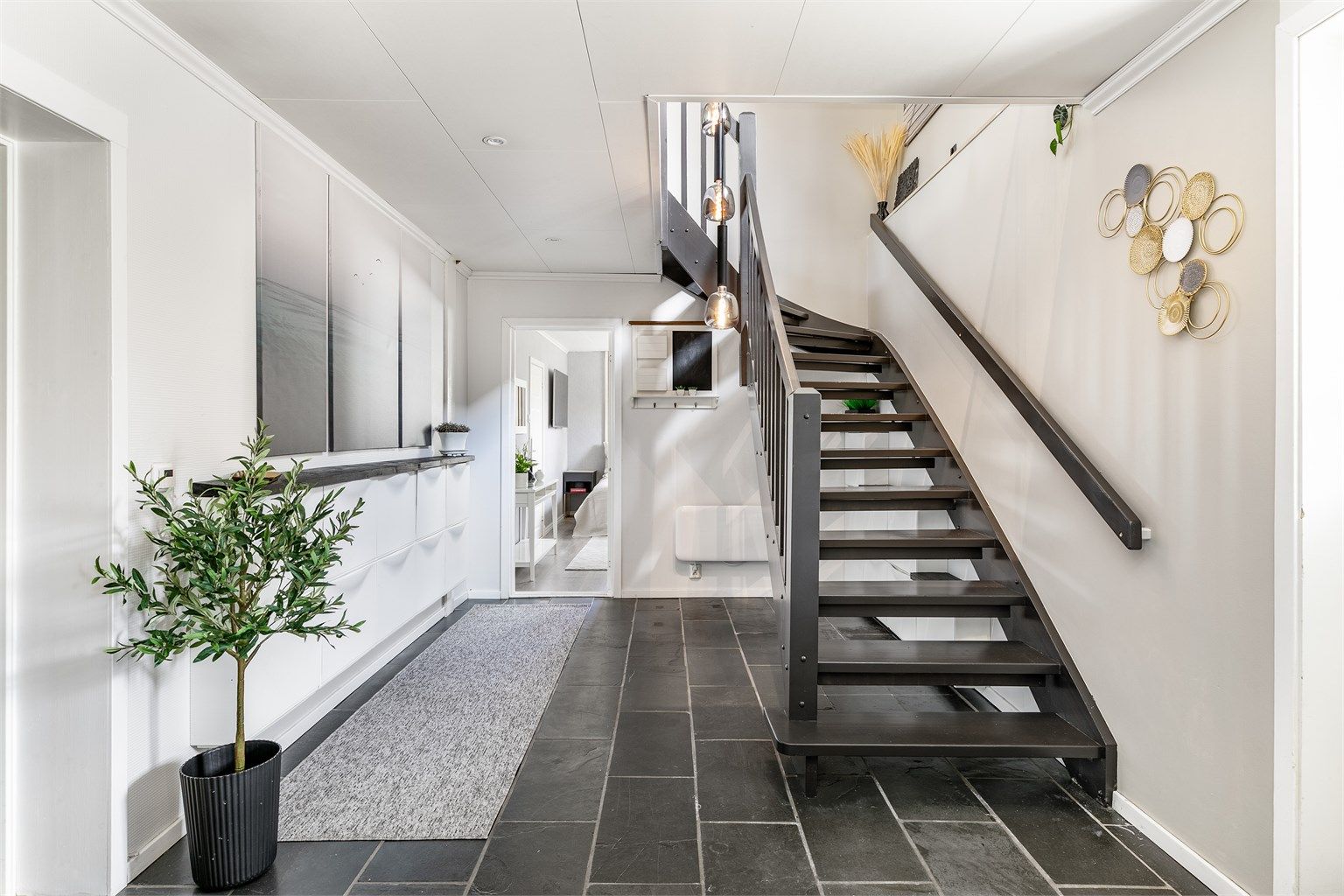 De fleste av underetasjens innredede rom er forbundet med dette, benyttet som entré. Også her er det varmekabler i gulvet, som for øvrig har en praktisk overflate av fliser.