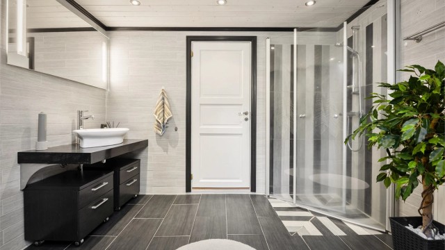 Badet har dusjhjørne med innfellbare dører av glass.