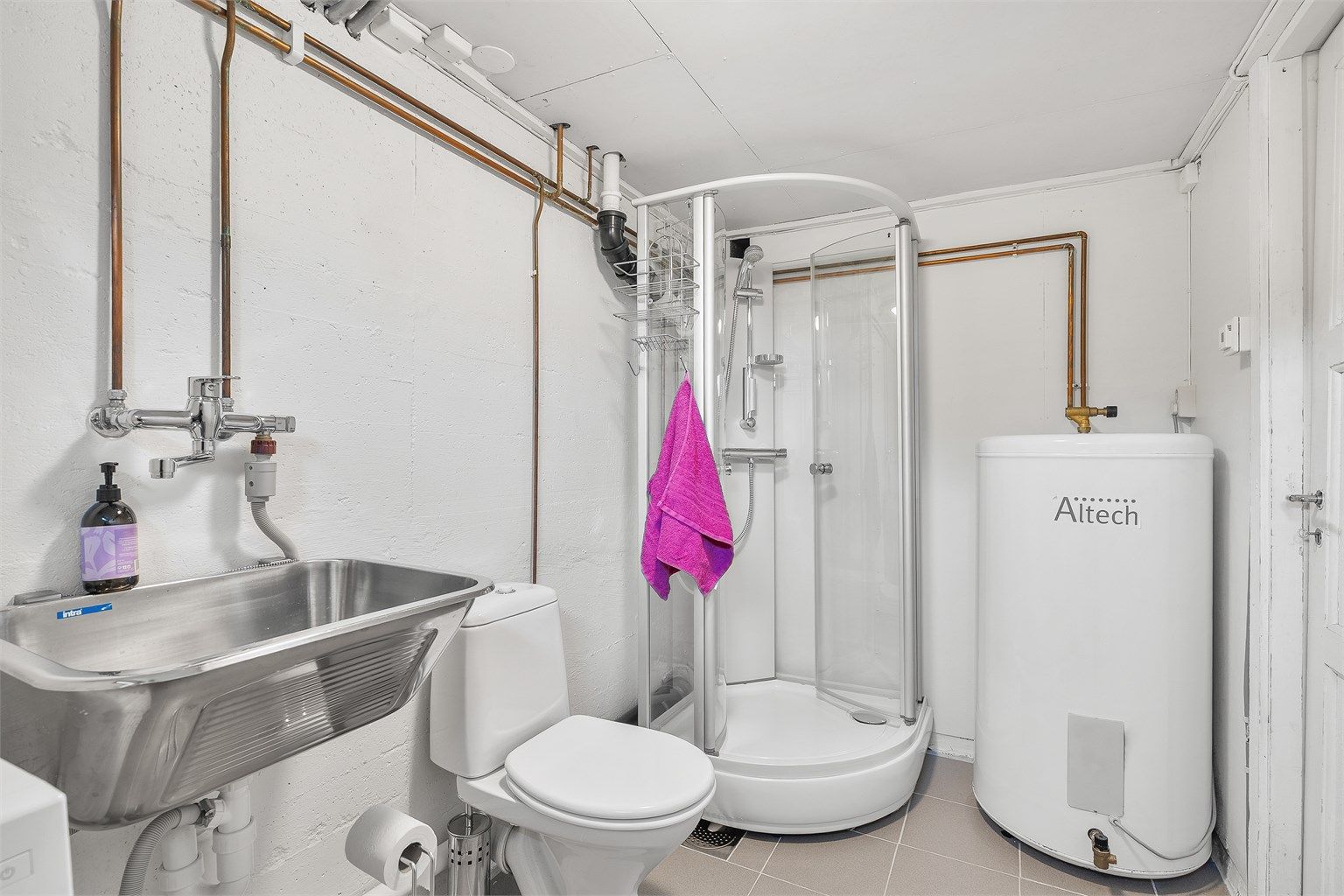 Utslagsvask med ett-greps armatur, dusjkabinett og toalett. Opplegg for vaskemaskin