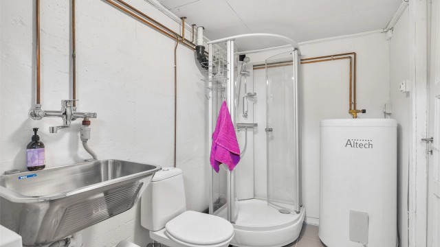 Utslagsvask med ett-greps armatur, dusjkabinett og toalett. Opplegg for vaskemaskin