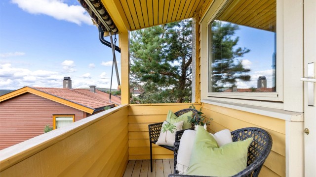 Balkongen er belagt med terrassebord og har både belysning og stikkontakt