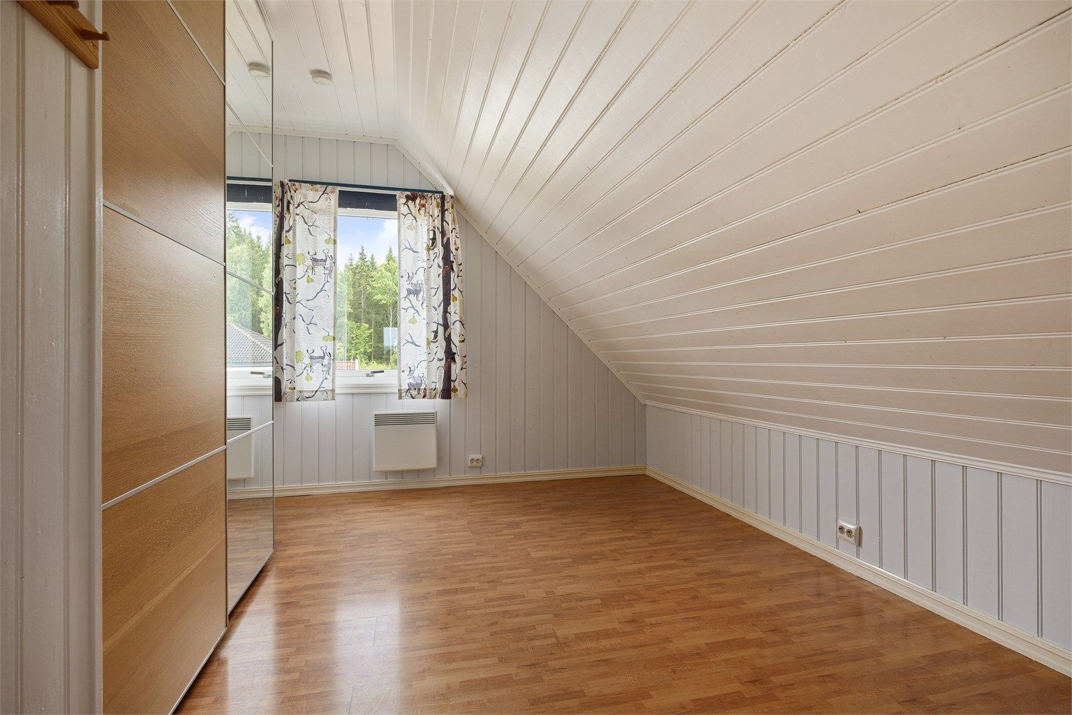 Et av tre soverom i loftsetasjen, med plass til garderobe.