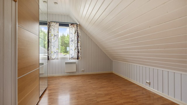 Et av tre soverom i loftsetasjen, med plass til garderobe.