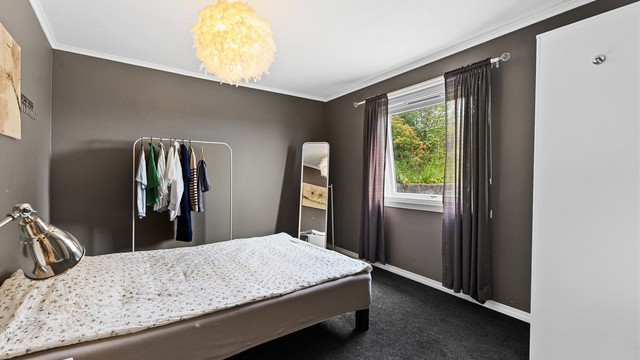 Fra gangen kommer du videre inn til et romslig soverom med plass til seng og det du måtte trenge av tilhørende møblement.