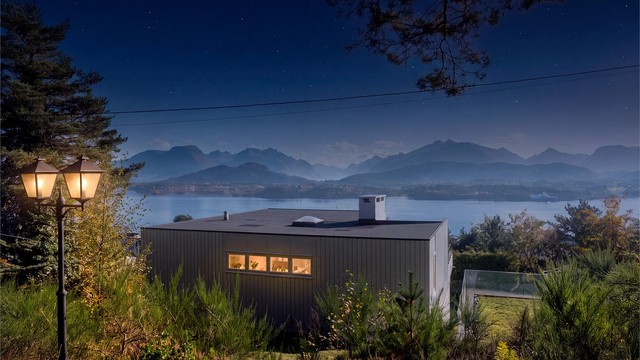 Kveldsutsikt fra bakhagen mot boligen og fjellene i det fjerne.