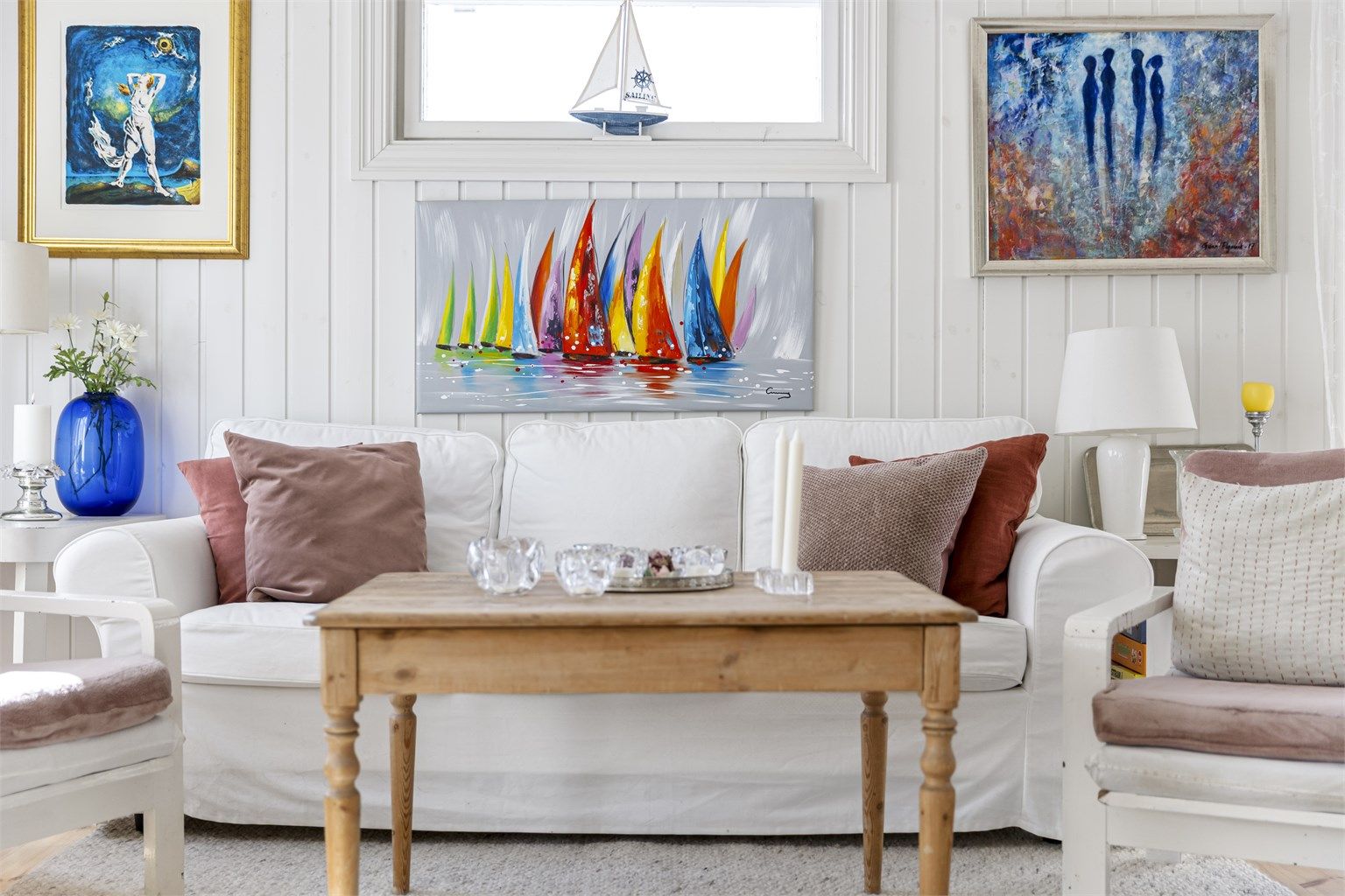 Lyse overflater og flere vinduer gir en luftig følelse i stuen.