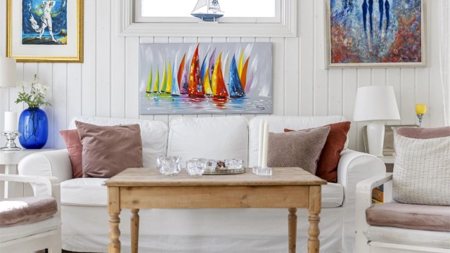 Lyse overflater og flere vinduer gir en luftig følelse i stuen.