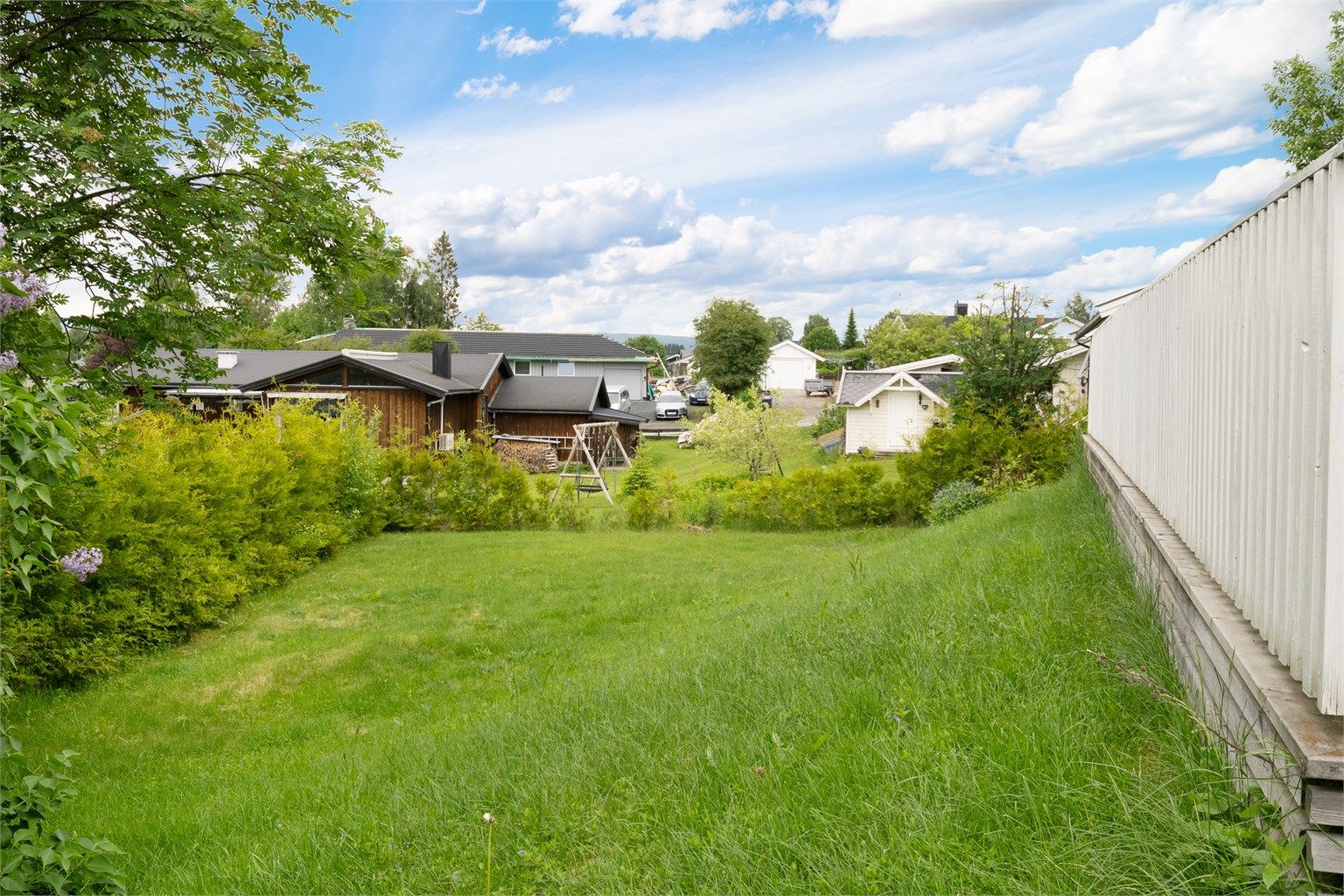 Eiendommen har en pent opparbeidet tomt med plenarealer og beplantning.