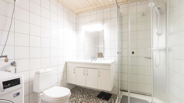 Flislagt bad med varmekabler. Dusjkabinett, servantinnredning, wc og opplegg til vaskemaskin