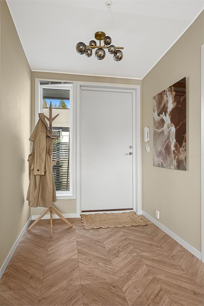 Hyggelig entrè, med plass til å henge fra yttertøy. Entréen oppleves som lys og luftig, samt gir ett godt første inntrykk av leiligheten. Foto: Boligfotograf1 v/ Dag Frogner.