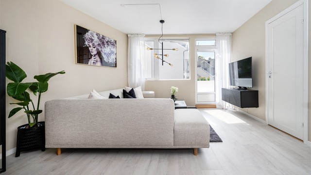 Leiligheten er gjennomgående og har et luftig og åpent stue-kjøkkenrom med god plass til flere møbleringssoner. Legg og merke til luftevinduet over balkongdøren
