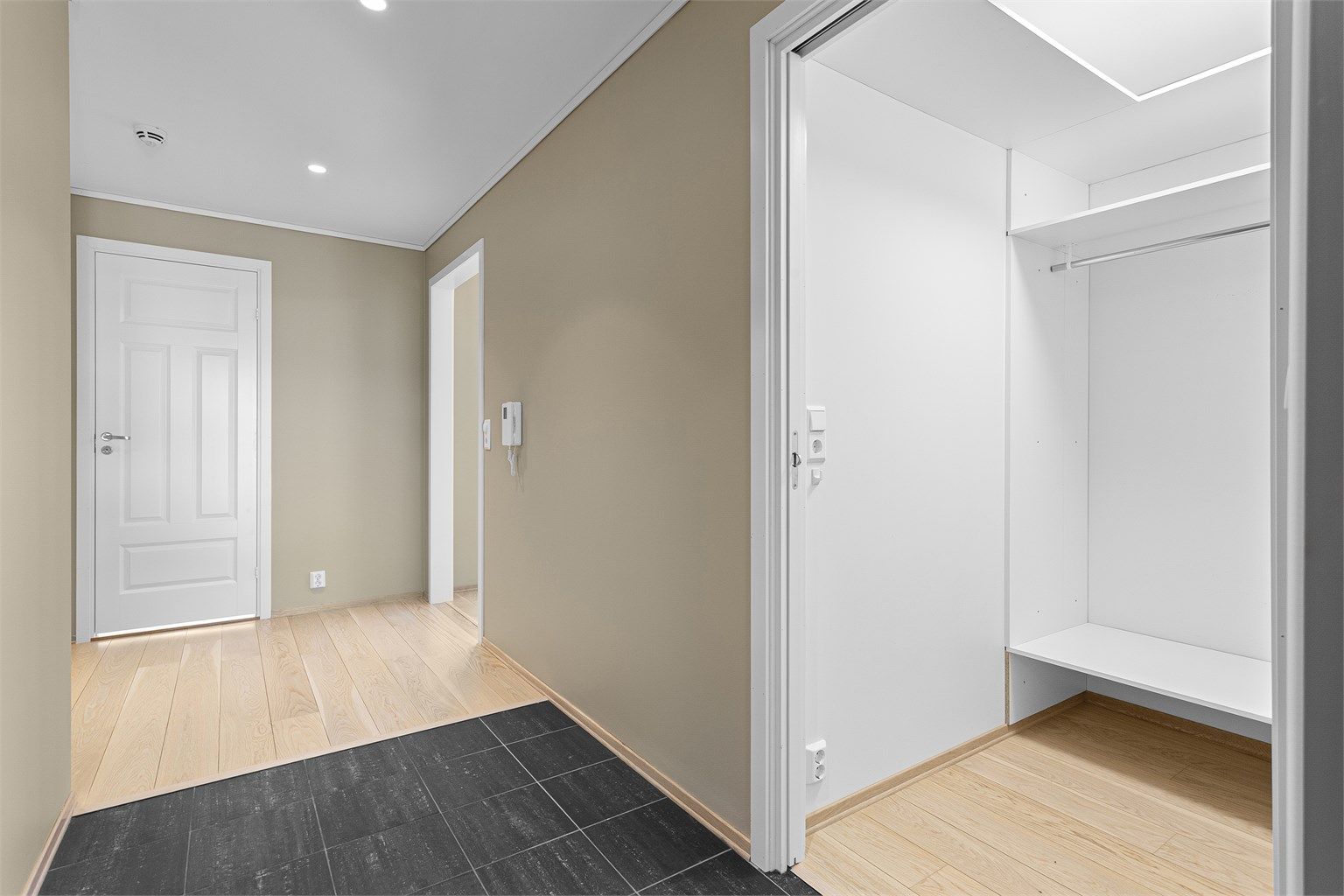 Entré med fliser i inngangspartiet og en praktisk garderobe for yttertøy.