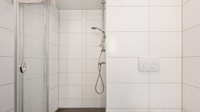 Vegghengt toalett, dusjhjørne med innfellbare dører, servant med skuffer og opplegg for vaskemaskin. Det er også plass til tørketrommel.