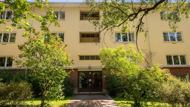 Leilighetens fasade, pent opparbeidet og hyggelig uteområde.