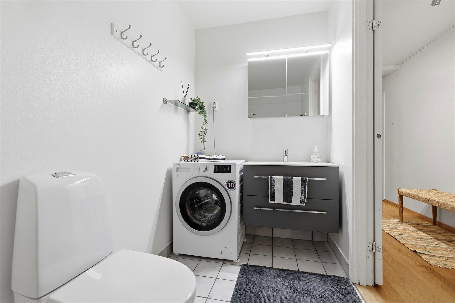 Leilighetens bad/wc har varmekabler i gulvet for lun varme, det er montert en moderne baderomsinnredning med  hvit servanttopp og fint speilskap med lys over