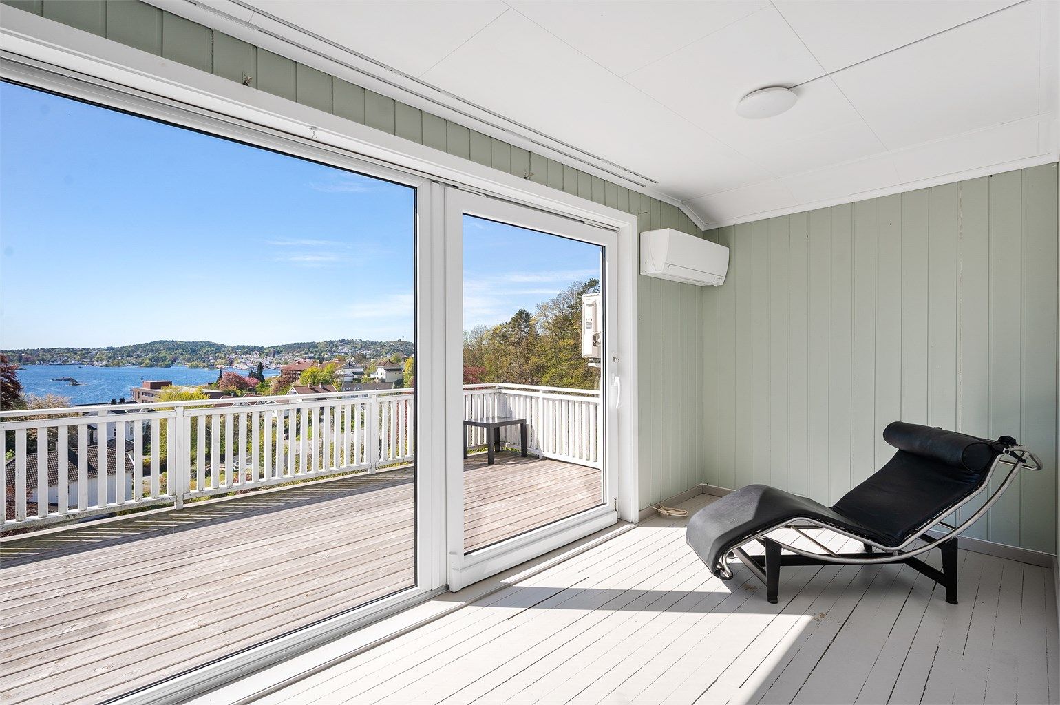 Stue i 3. etasje med store vindusflater hvor utsikten kommer frem. Her er det også utgang til egen terrasse