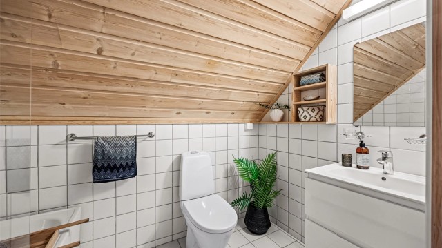 Flislagt bad med badekar, servantskap og toalett.