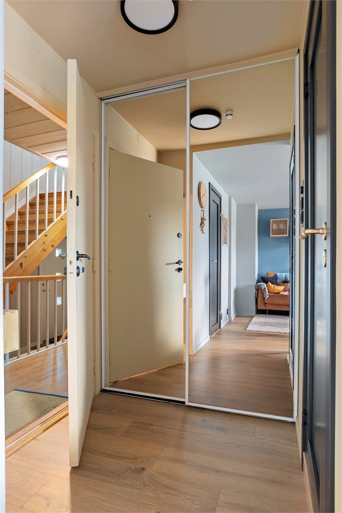 Man kommer inn i en lys og funksjonell entré, med skyvedørsgarderobe for oppbevaring.