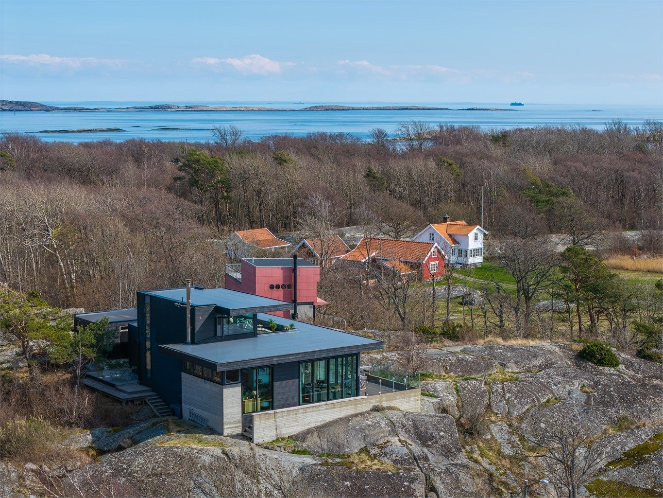 Boligen er fundamentert direkte på fjellet, og kombinasjonen av betong, tre og store glassflater skaper en unik dialog med den omkringliggende naturen og havet.