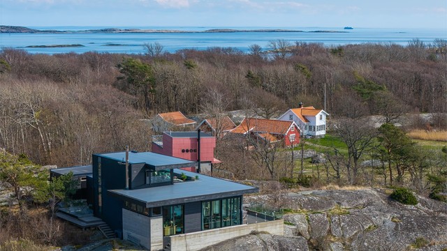 Boligen er fundamentert direkte på fjellet, og kombinasjonen av betong, tre og store glassflater skaper en unik dialog med den omkringliggende naturen og havet.