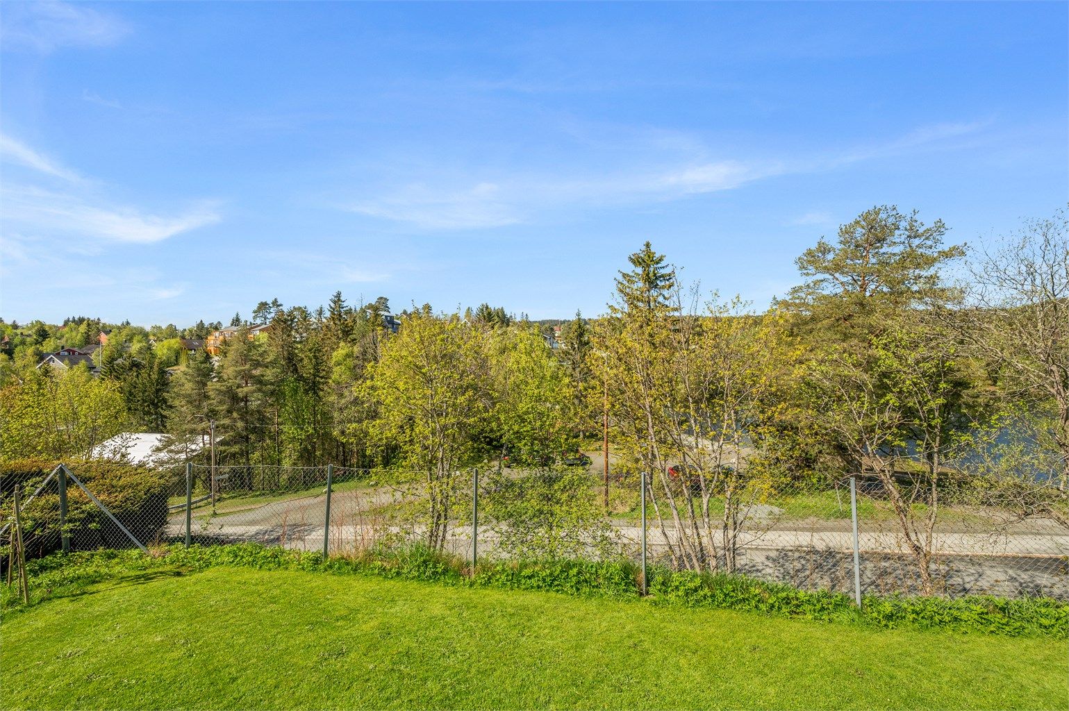 Fra balkongen har man enkel tilgang til felles hage. Tomten er pent opparbeidet med blant annet grus, plenarealer og andre forskjellige beplantninger. 