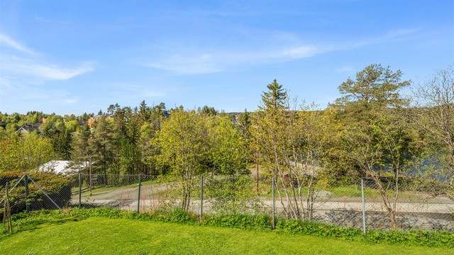 Fra balkongen har man enkel tilgang til felles hage. Tomten er pent opparbeidet med blant annet grus, plenarealer og andre forskjellige beplantninger.