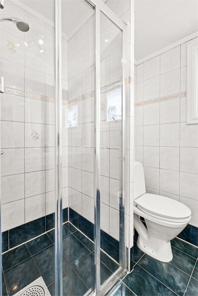 Dusjnisje med glassvegg og glassdør.