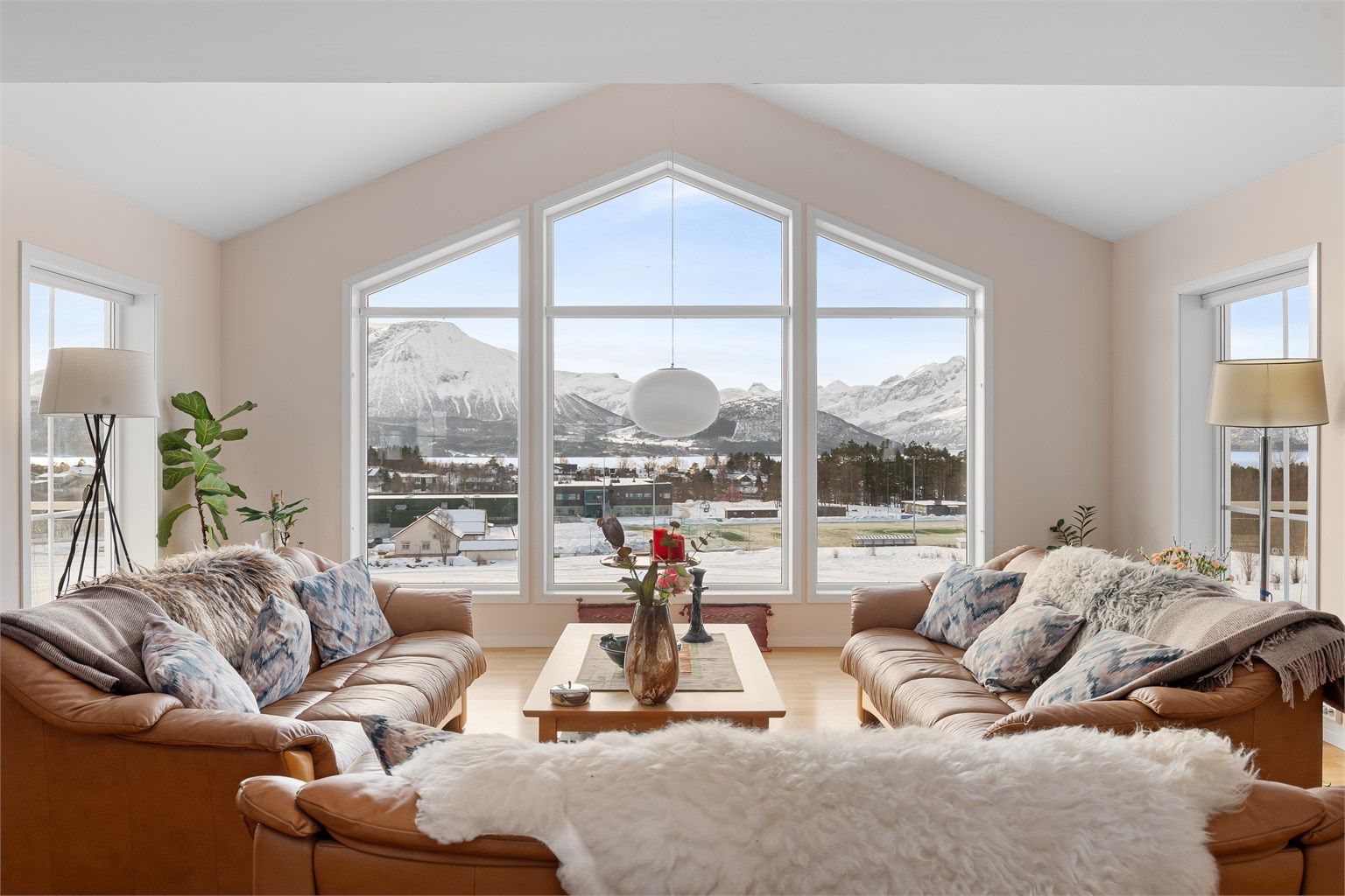De store, spesialtilpassede vinduene rammer inn en storslått utsikt mot fjellheimen.