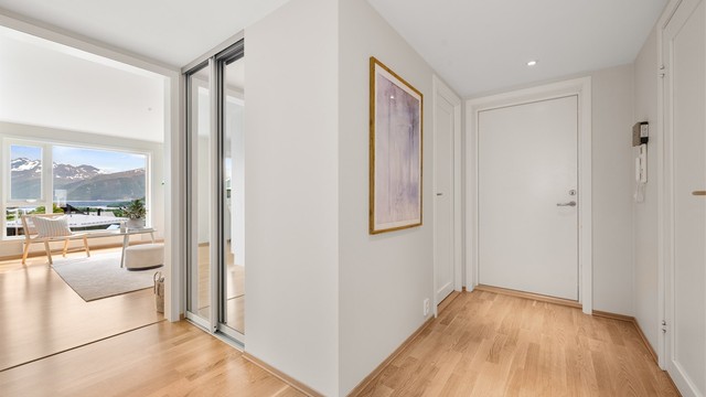 Lys entré med parkett på gulv og plass til garderobeløsning.
