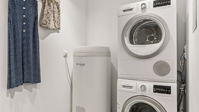Vaskerom i kjelleretasjen med flislagt gulv med varmekabler og malte slette flater med downlights i himling, samt opplegg for vaskemaskin og tørketrommel.