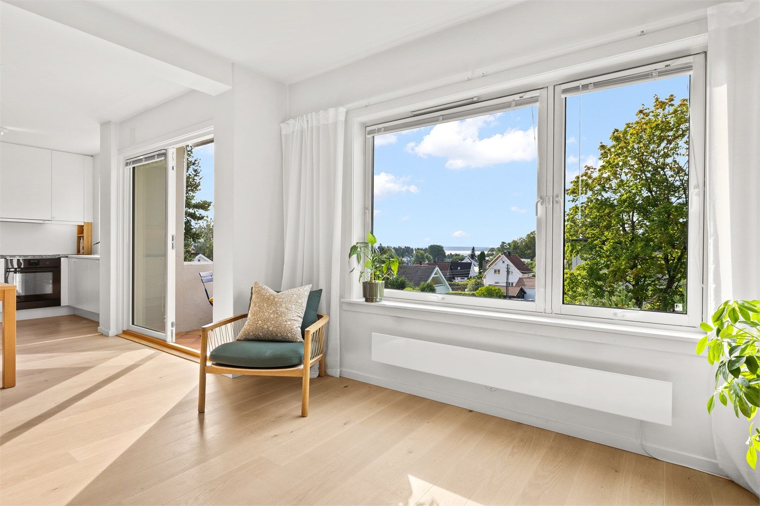 Stue og kjøkken byr på vakker utsikt mot fjorden og nærliggende villaområde.