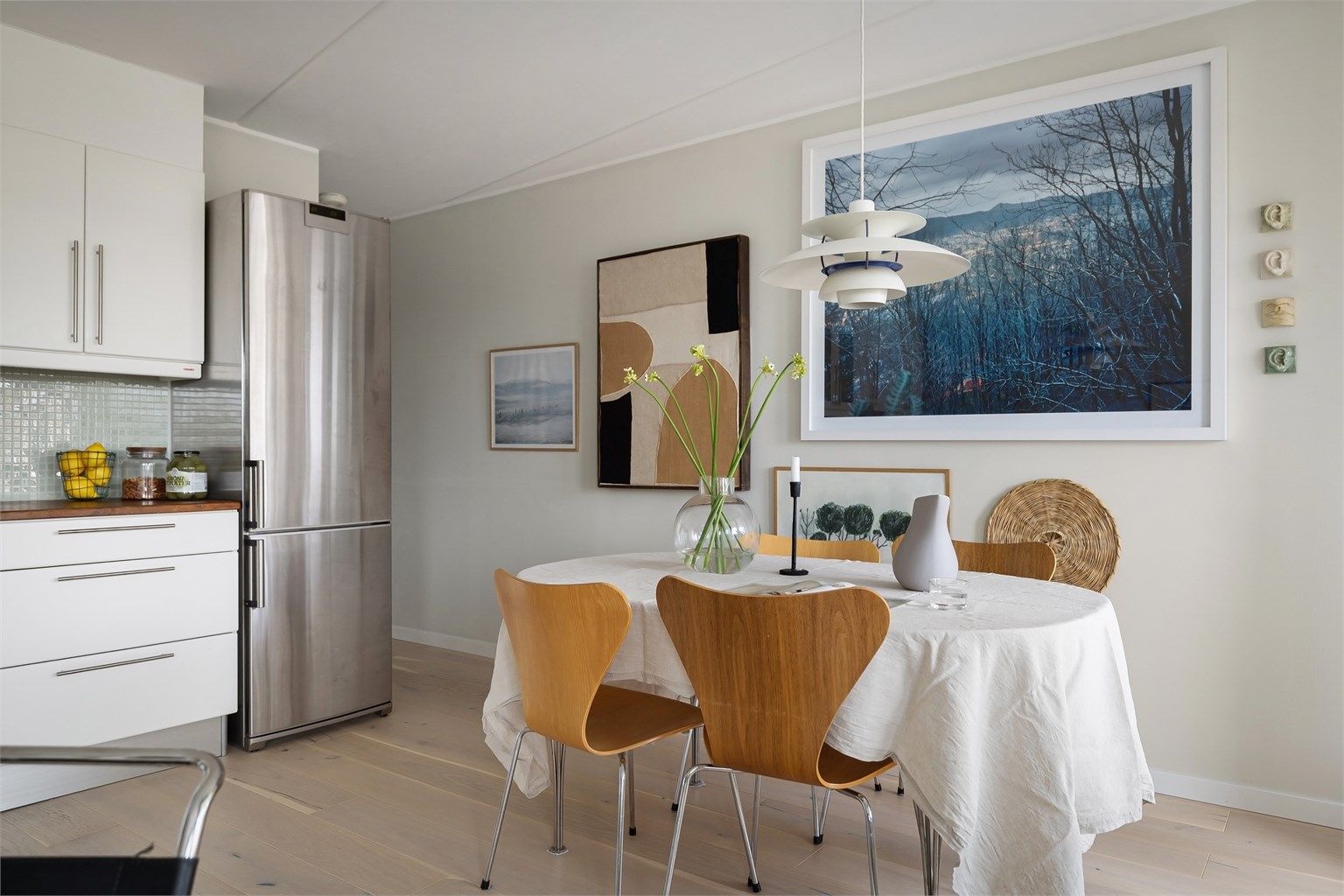 Integrerte hvitevarer som stekeovn, platetopp med ventilator over, oppvaskmaskin og frittstående kjøleskap med frysedel