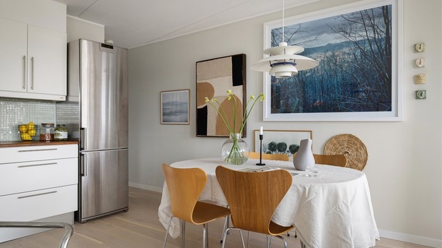 Integrerte hvitevarer som stekeovn, platetopp med ventilator over, oppvaskmaskin og frittstående kjøleskap med frysedel