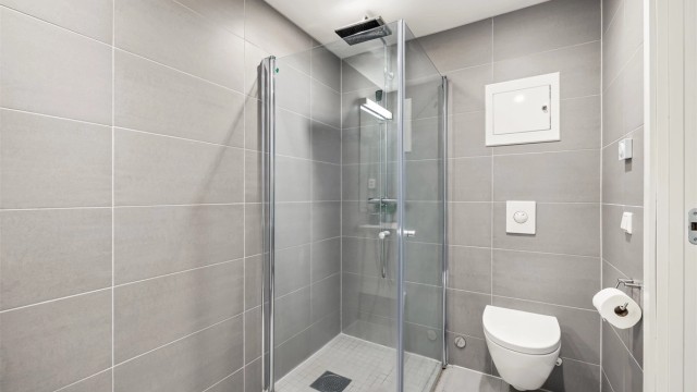 Badet har dusjhjørne med regnfallsdusj, downlights i tak og gulvvarme