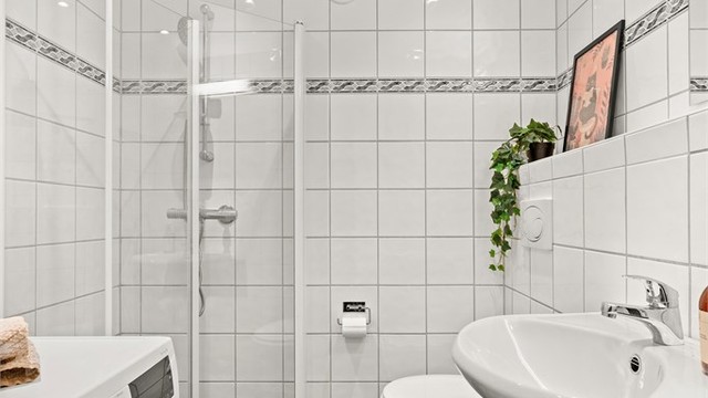 Romslig og funksjonelt bad med god planløsning. vegghengt toalett og opplegg for vaskemaskin bidrar til en praktisk og moderne romutnyttelse.
