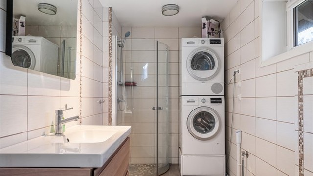 Også dette badet er fra 2015, med fliser, gulvvarme og opplegg for vaskemaskin.