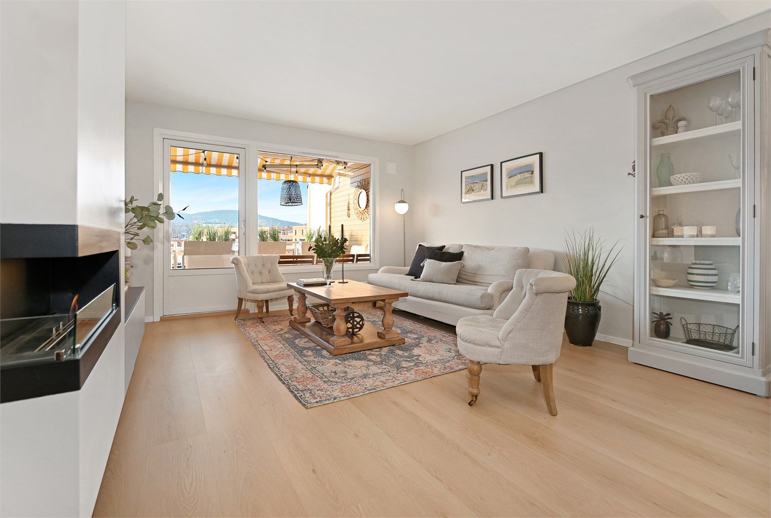 En gjennomgående 4-roms leilighet med høy standard og en sentralt plassert gasspeis i stuen.