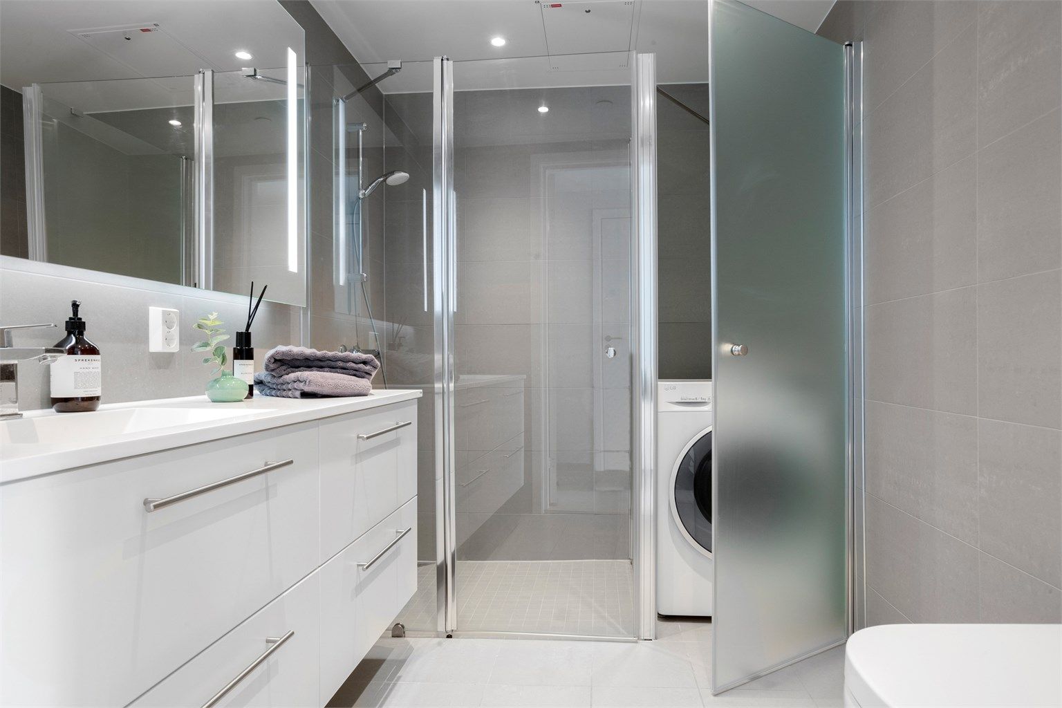 Badet er utstyrt med dusjnisje med glassvegger, vegghengt toalett og opplegg for vaskemaskin.