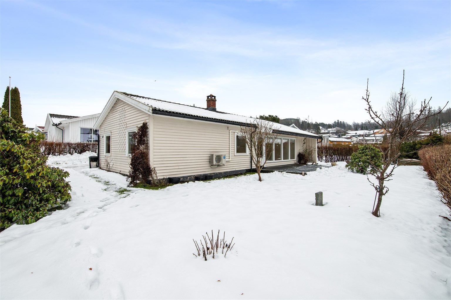 Mot vest og rundt store deler av boligen finnes det også arealer med gressplen - perfekt til lek og moro for både store og små. Hagen er godt skjermet fra veien med hekk, slik at de minste kan leke i trygge omgivelser.