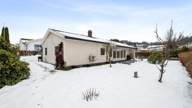 Mot vest og rundt store deler av boligen finnes det også arealer med gressplen - perfekt til lek og moro for både store og små. Hagen er godt skjermet fra veien med hekk, slik at de minste kan leke i trygge omgivelser.