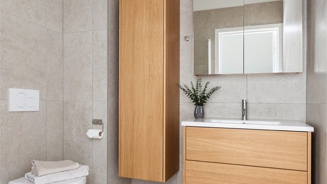 Begge badene har flislagt gulv med gulvvarme, vegghengt toalett og downlights i taket.