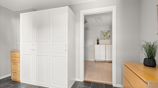 Innbydende og romslig entré med downlights i himlingen og flislagt gulv med varmekabler. Garderobeskap gir gode oppbevaringsmuligheter for yttertøy og sko.