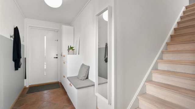 Entré med fliser på gulv, varmekabler, malte vegger og god plass til å henge av yttertøy. Fra entré er det trapp opp til 2.etg og glassdør inn til stue.