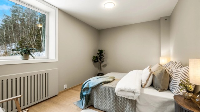 Romslig hovedsoverom med parkett på gulv og oppvarming via radiator.