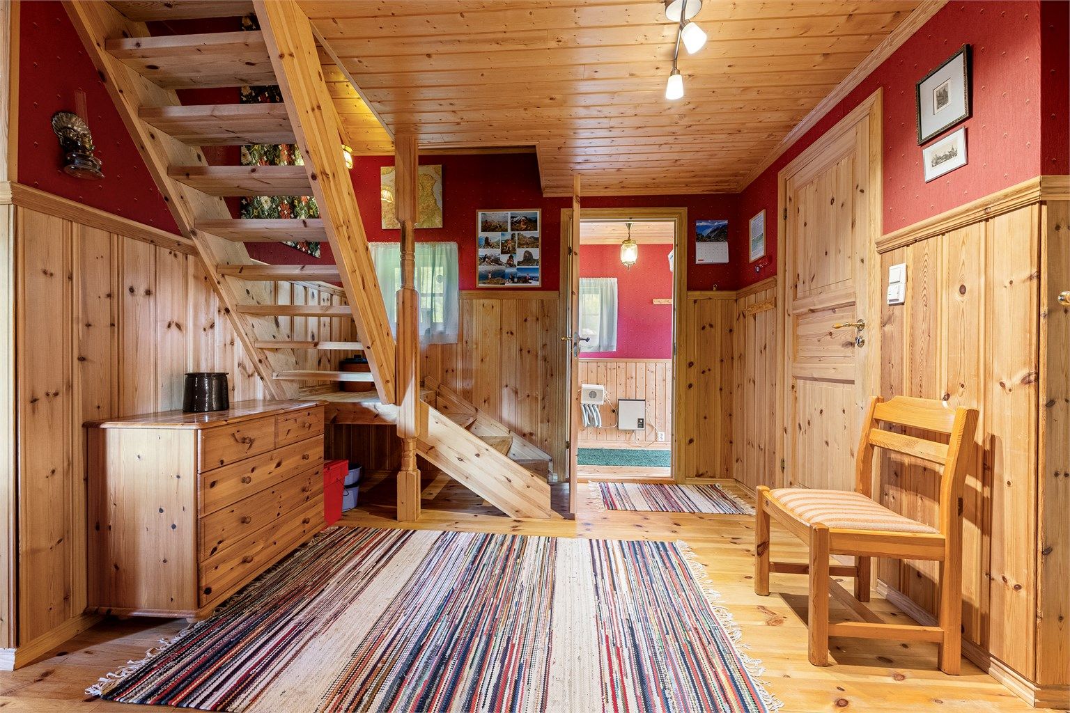 Gjennomgående bruk av furubord på gulv og panel i himling.