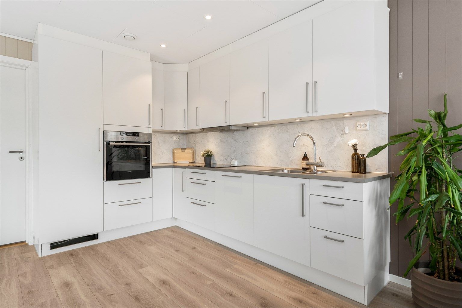 Downlights i himlingen og belysning under overskapene gir godt arbeidslys på kjøkkenet.