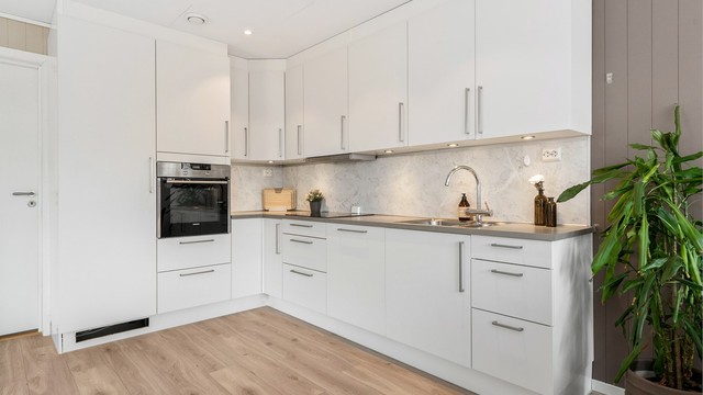 Downlights i himlingen og belysning under overskapene gir godt arbeidslys på kjøkkenet.