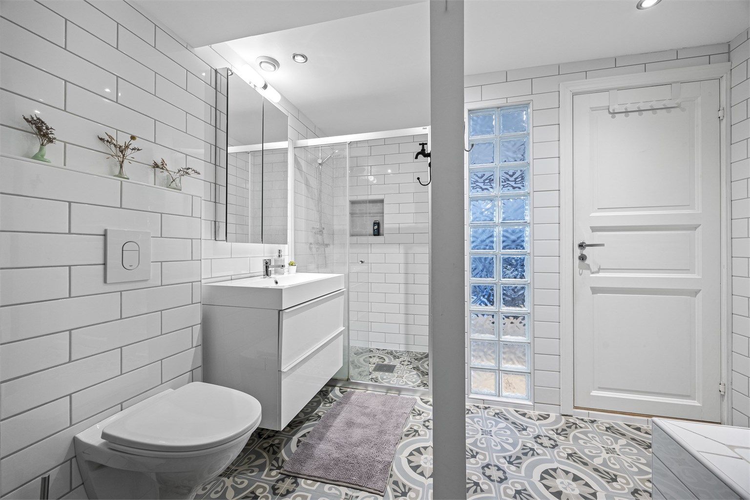 Badet i tredje etasje er flislagt og utstyrt med både badekar og dusjnisje.