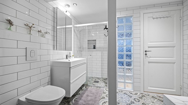 Badet i tredje etasje er flislagt og utstyrt med både badekar og dusjnisje.