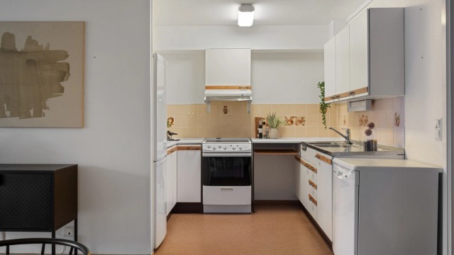 Kjøkkeninnredning med slette fronter og benkeplate i laminat med og vask med stålbeslag. Opplegg for frittstående oppvaskmaskin.